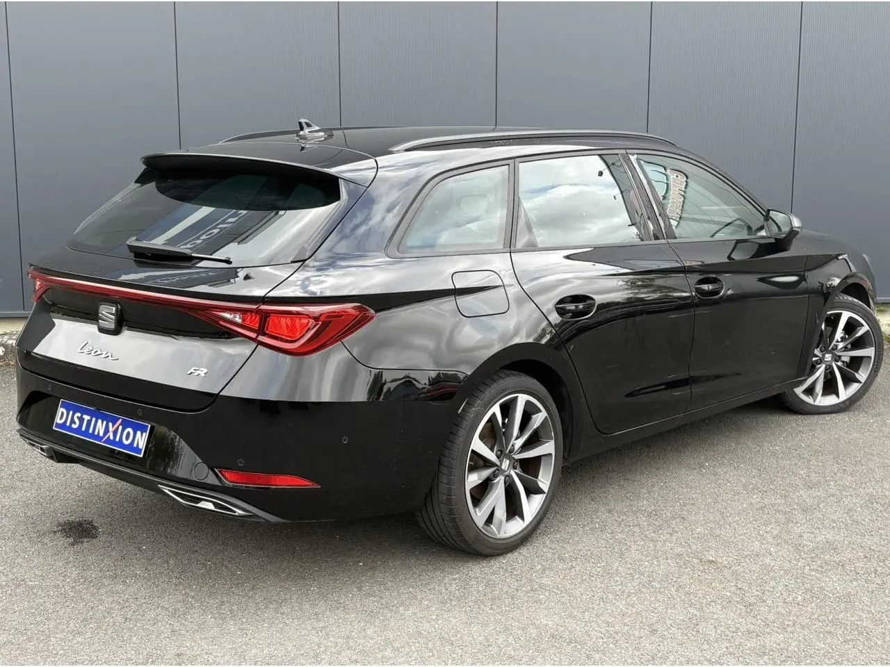 SEAT Leon 1.5 e-TSI 150 FR noir Minuit vue 3/4 arrière droit avec jantes alliage 18 pouces et feux arrière LED.