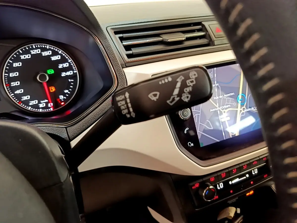 Vue rapprochée de l’intérieur du SEAT Arona gris clair 2019, montrant le volant, tableau de bord et écran tactile de navigation.