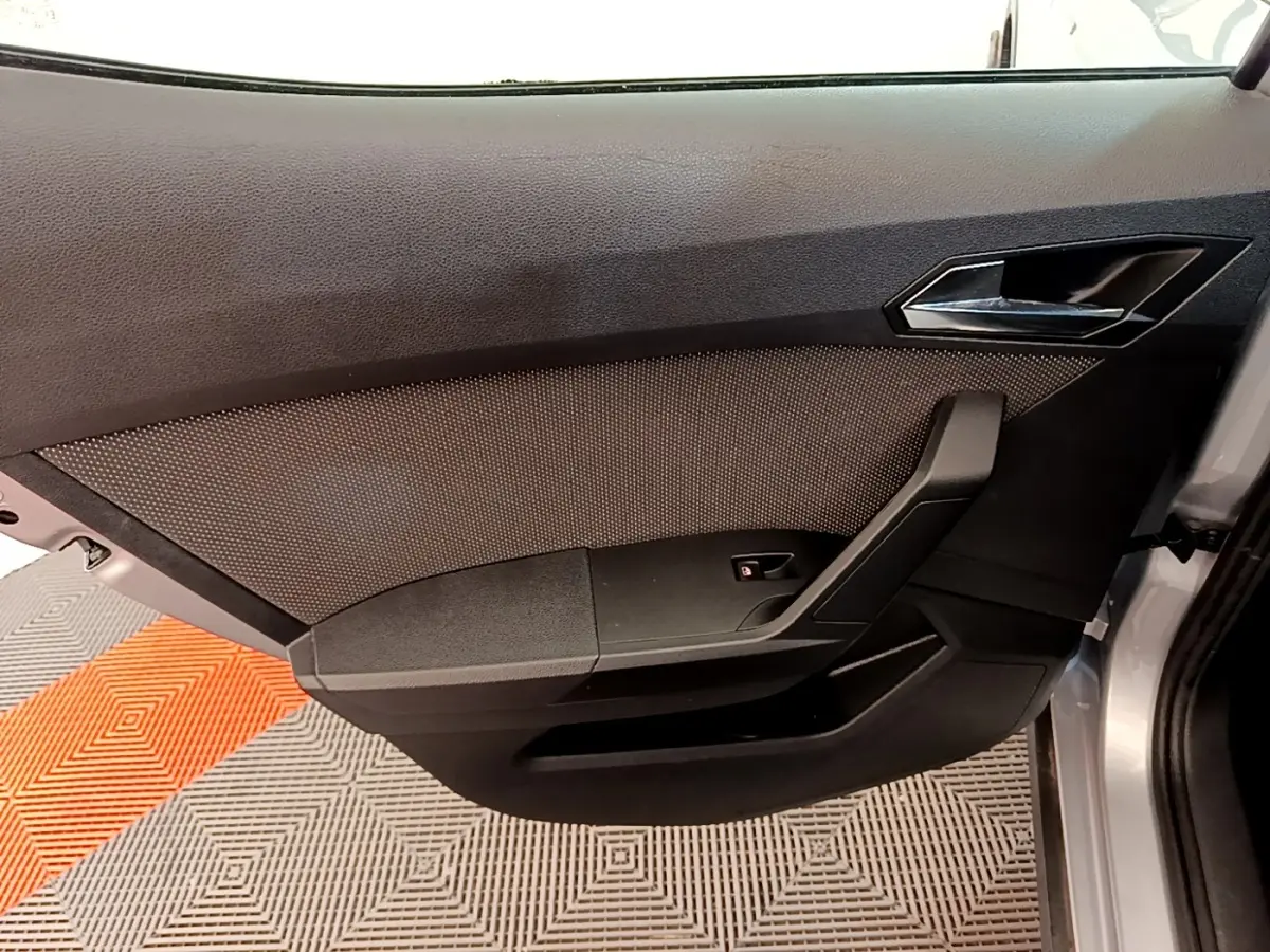 Vue intérieure de la porte avant droite gris clair du SEAT Arona 2019 avec poignée et bouton de verrouillage.
