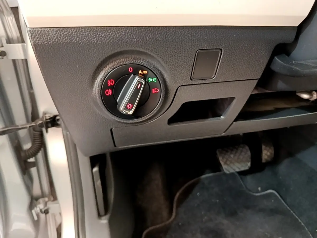 Gros plan sur le bouton de commande des phares dans l'habitacle gris clair du SEAT Arona 2019, côté conducteur.