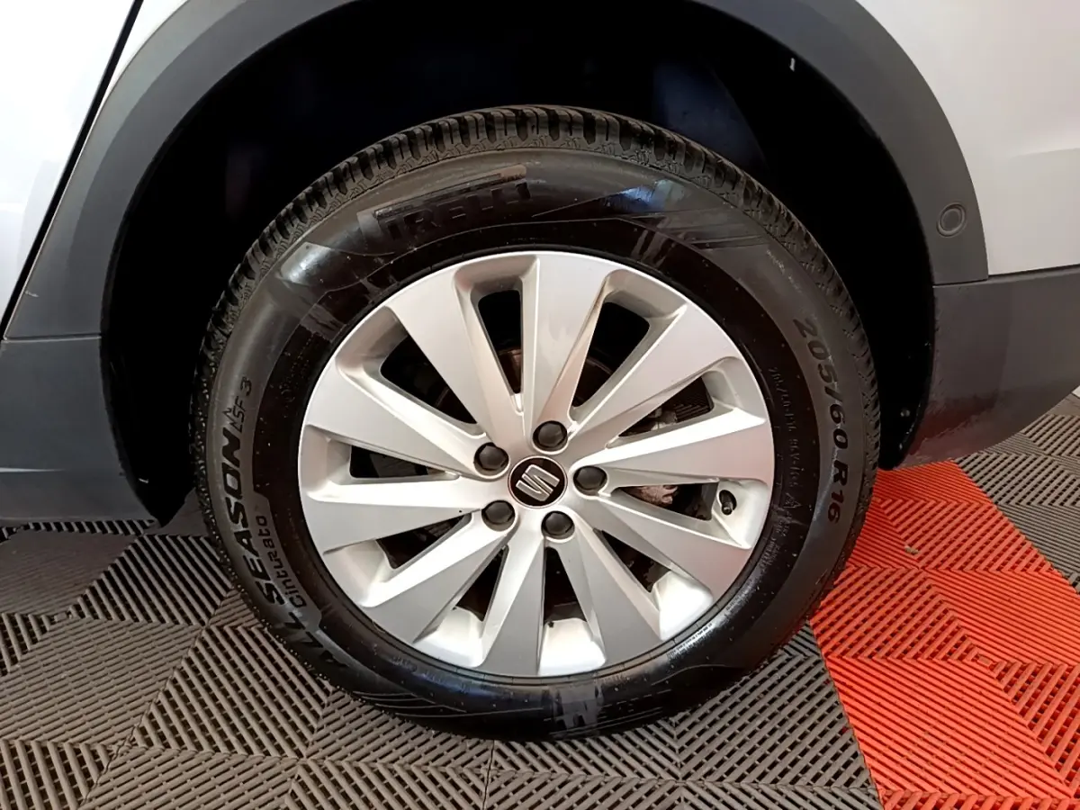 Gros plan sur la roue avant droite d'un SEAT Arona gris clair, avec jante alliage et pneu Pirelli.