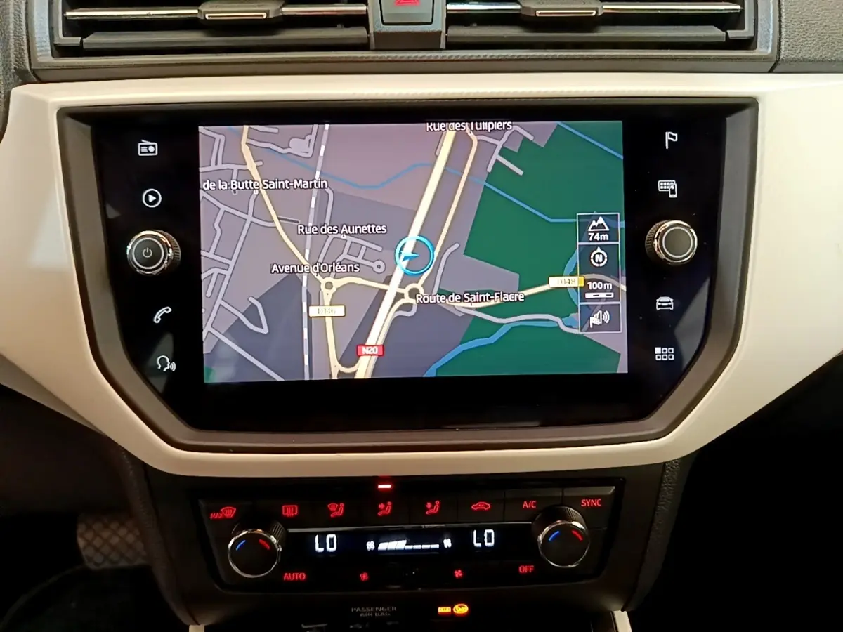 Écran tactile central avec navigation affichée et commandes climatisation digitales dans un SEAT Arona gris clair 2019.