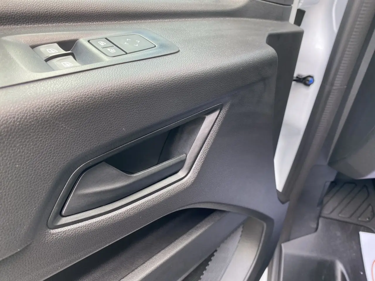 Détail de la porte intérieure côté conducteur du Renault Master 2025, avec commandes de vitres et poignée noire.