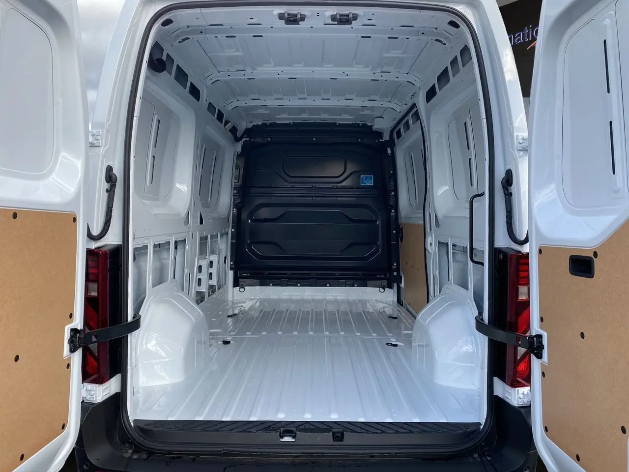 Vue arrière ouverte du Renault Master blanc 2025, montrant l'intérieur vide et spacieux de la zone de chargement.