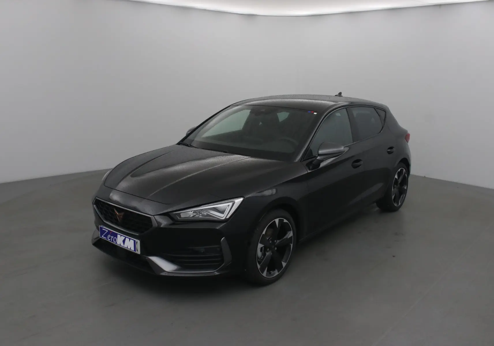 Vue 3/4 avant d'une CUPRA Leon noire 2023 avec jantes noires et détails sportifs visibles.
