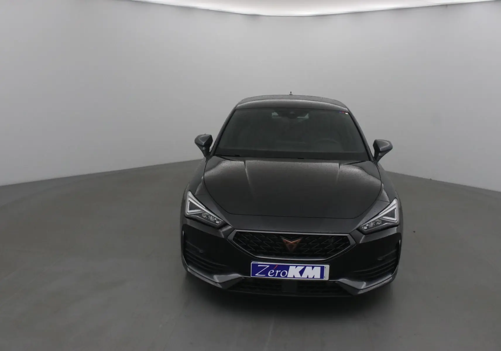 Vue frontale d'une CUPRA Leon noire 2023 avec phares LED anguleux et calandre noire distinctive.