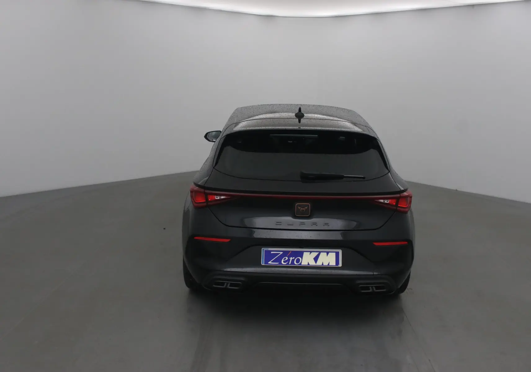 Vue arrière d'une CUPRA Leon noire 2023 avec feux LED et double sortie d'échappement intégrée.