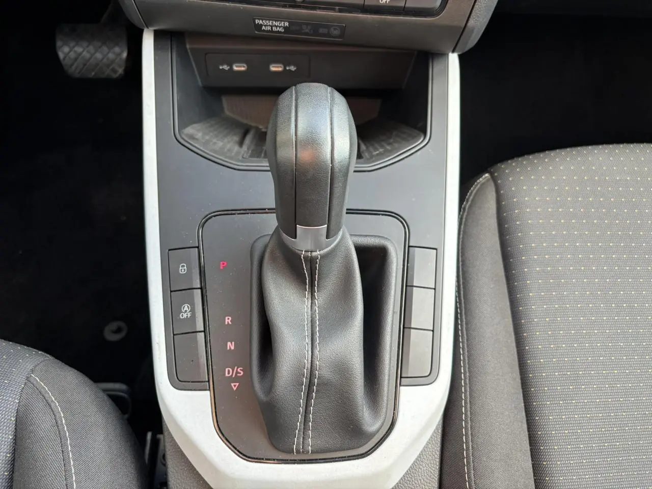 Vue rapprochée du levier de vitesses automatique noir et gris dans l'habitacle du SEAT Arona blanc, version Style TSI 115 DSG.
