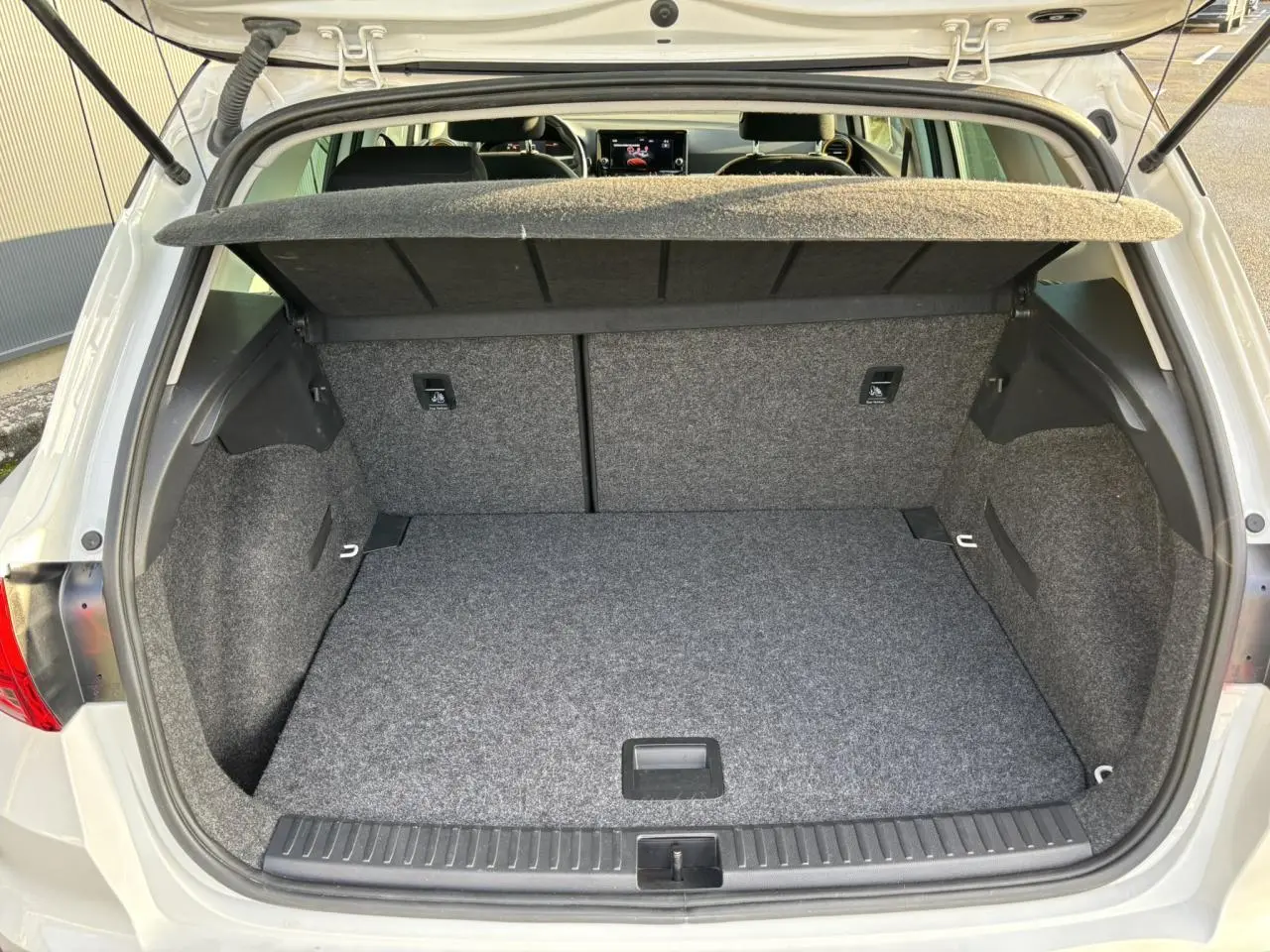 Vue arrière ouverte sur le coffre spacieux et tapissé en gris du SEAT Arona blanc 2025 TSI 115 DSG Style.