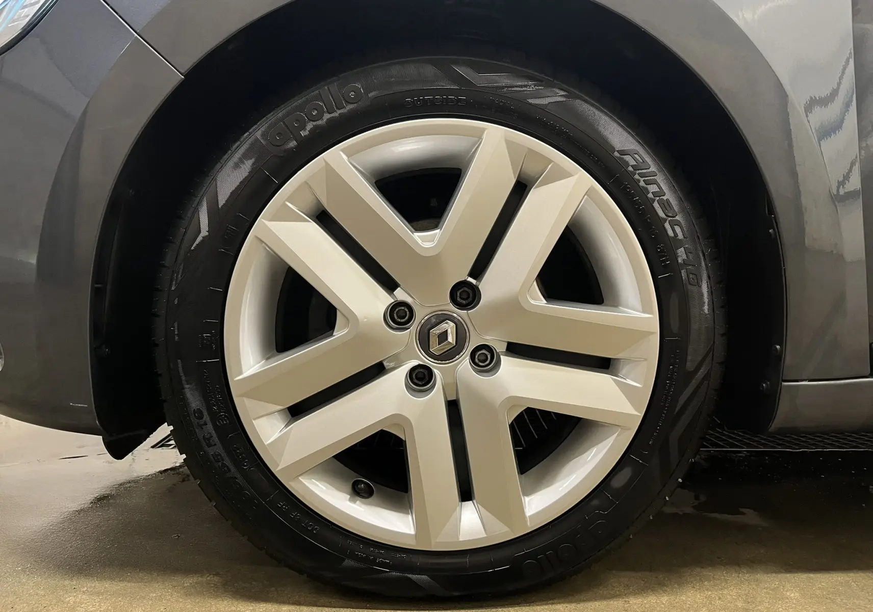 Gros plan sur la roue avant gauche d'une Renault Clio V Business gris titanium, mettant en valeur la jante alliage et le pneu Apollo.