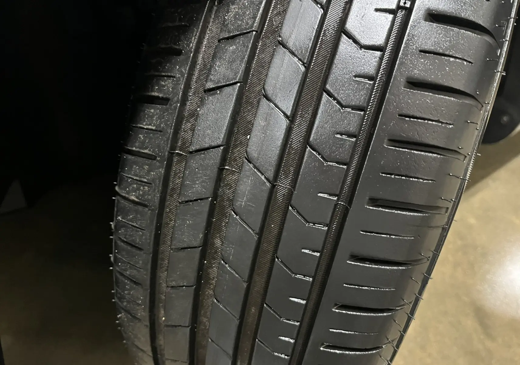 Gros plan sur le pneu avant d'une Renault Clio V gris titanium, montrant le profil et la bande de roulement neuve.