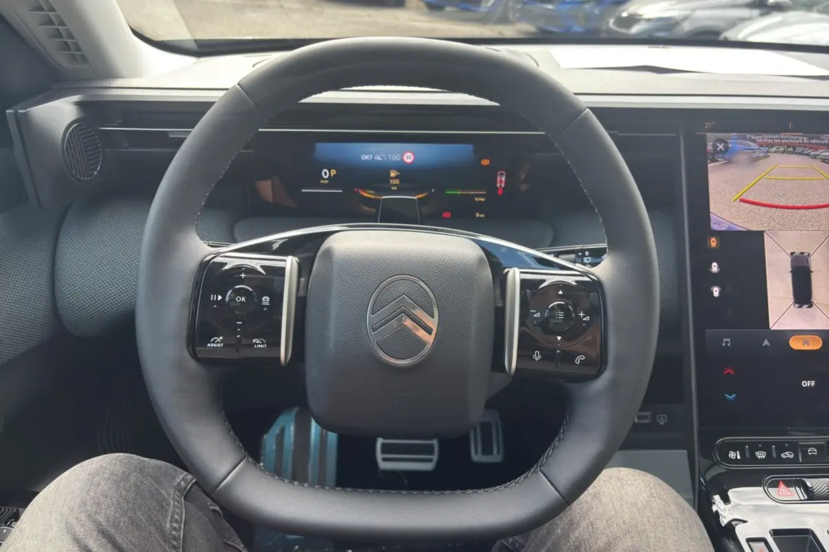 Vue intérieure centrée sur le volant cuir multifonctions de la Citroën C5 Aircross New Hybrid 2026 avec écran numérique.