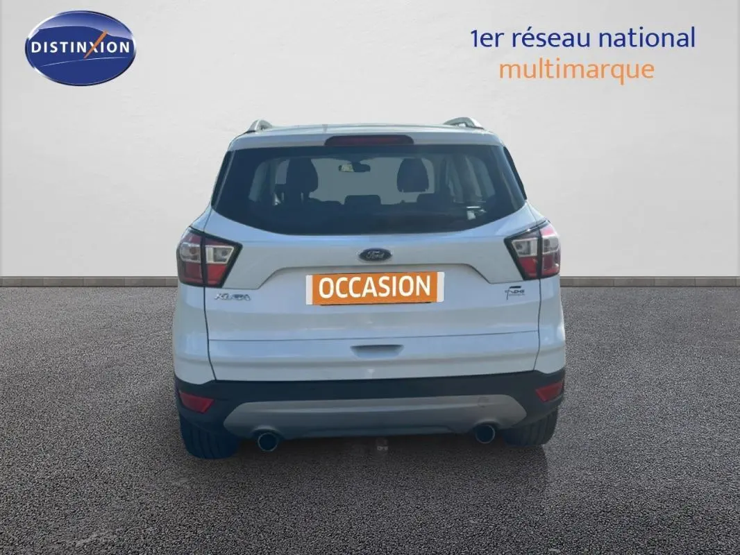 Vue arrière d’un Ford Kuga blanc 2019 avec barres de toit et double sortie d’échappement visible.