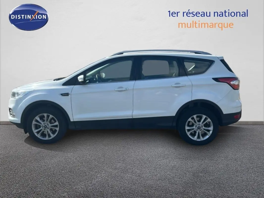 Vue latérale gauche d'un Ford Kuga blanc 2019 avec barres de toit et jantes alliage 17 pouces.