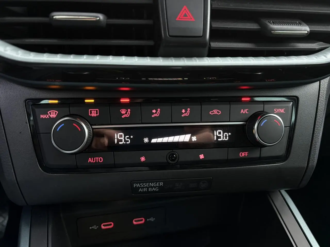 Gros plan sur la commande de climatisation automatique bi-zone du SEAT Arona gris, avec affichage digital et boutons rétroéclairés.