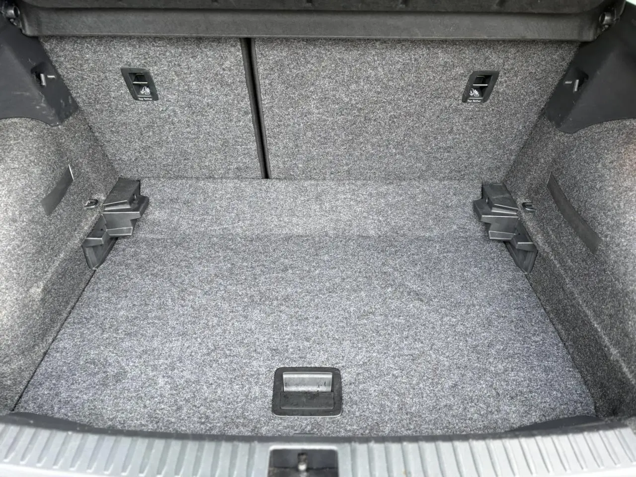 Coffre spacieux du SEAT Arona gris magnétique vu de face, avec revêtement gris et fixations ISOFIX visibles.