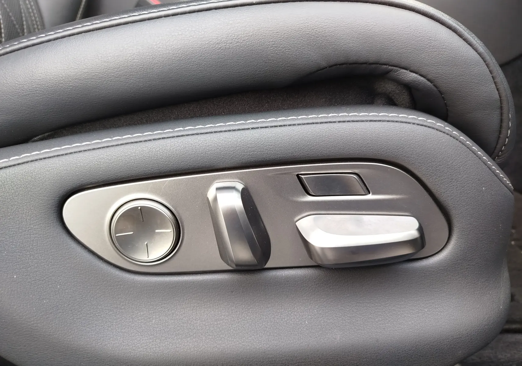 Gros plan sur les commandes de réglage électrique du siège en cuir noir d'une Lexus LS 500H gris manganèse, 2020.