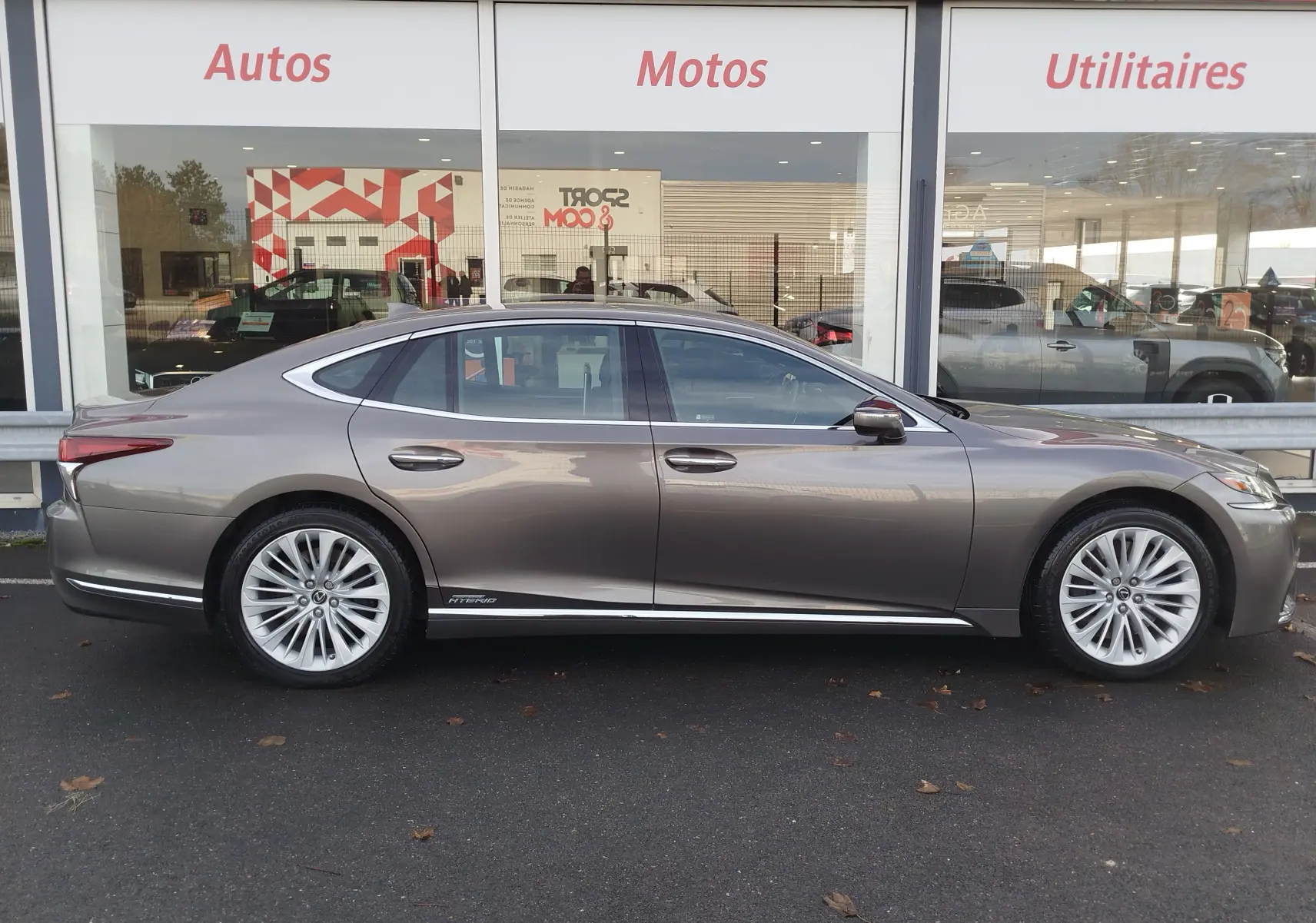 Profil droit d'une Lexus LS 500H gris manganèse, berline hybride élégante avec jantes alliage et lignes fluides.