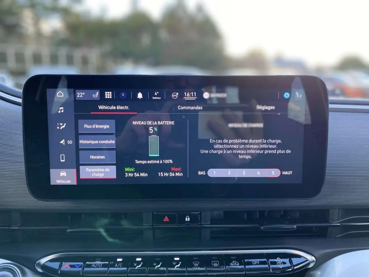 Écran tactile central affichant le niveau de batterie à 5% dans une Fiat 500 électrique noire, vue intérieure frontale.