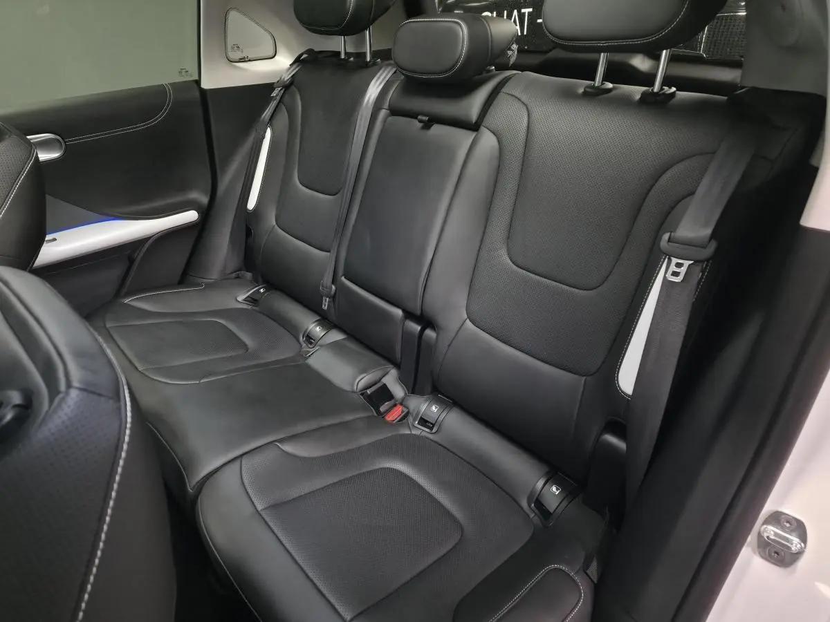 Vue intérieure côté droit sur la banquette arrière cuir noire du Smart #1 blanc électrique 2024 avec appuie-têtes réglables.