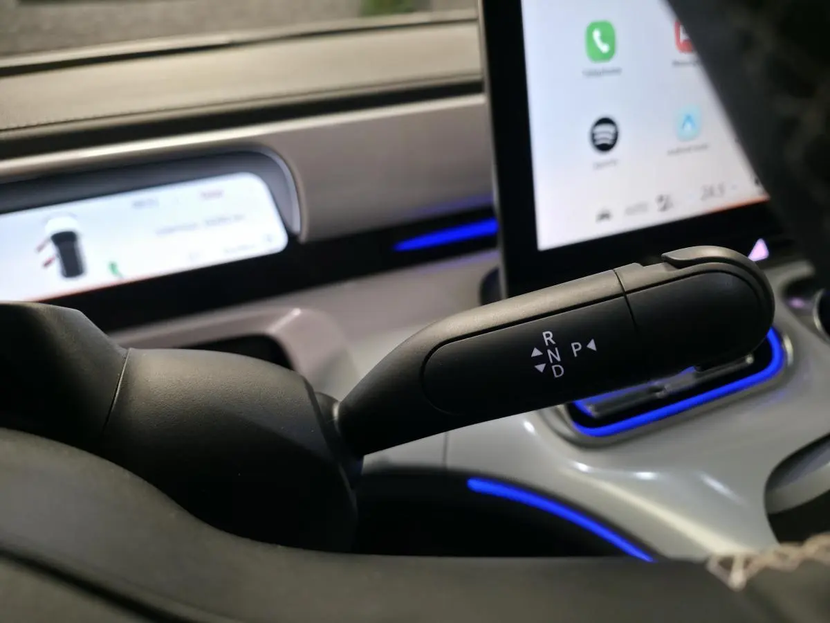 Le levier de boîte automatique noir du Smart #1 2024 visible côté conducteur avec écran tactile et éclairage bleu.