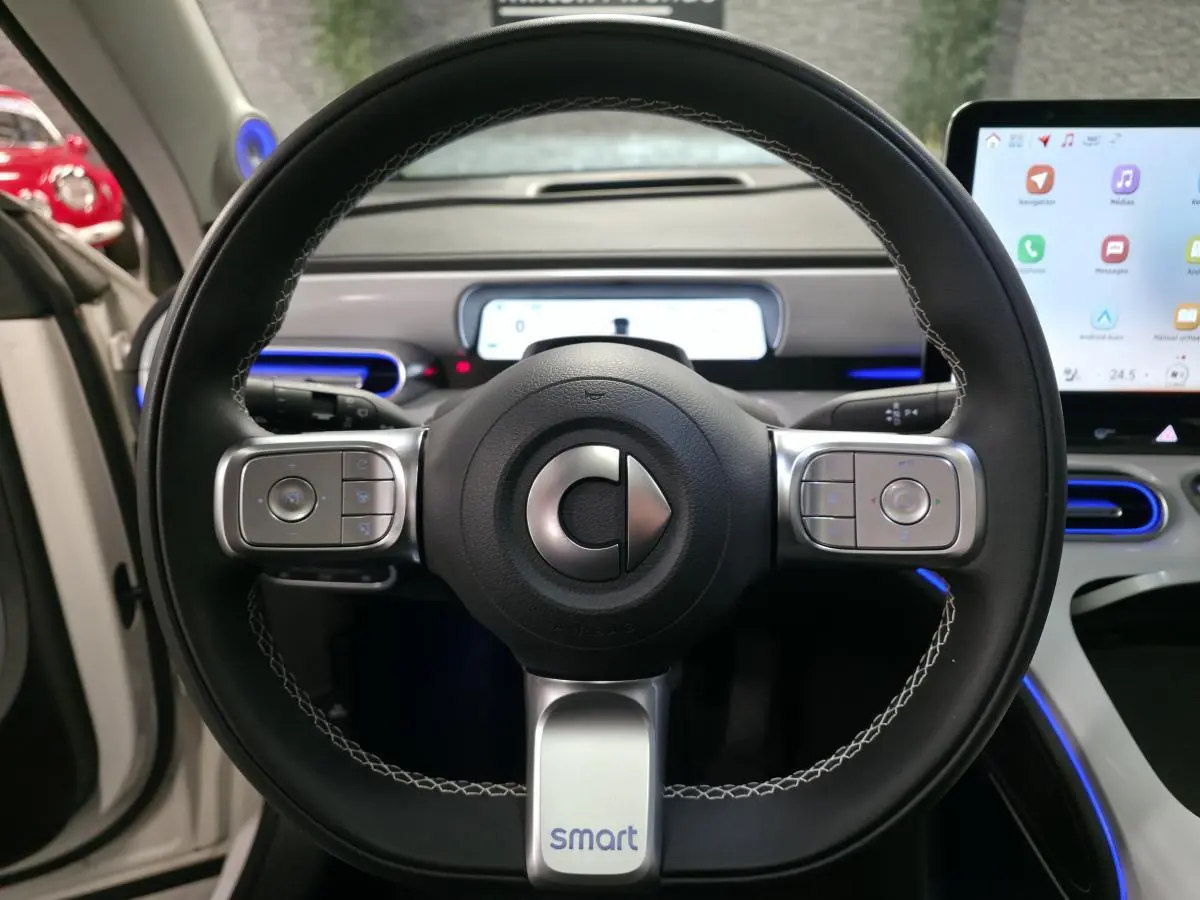 Volant cuir multifonction vu de face dans une Smart #1 blanche 2024 avec tableau de bord numérique et écran tactile.
