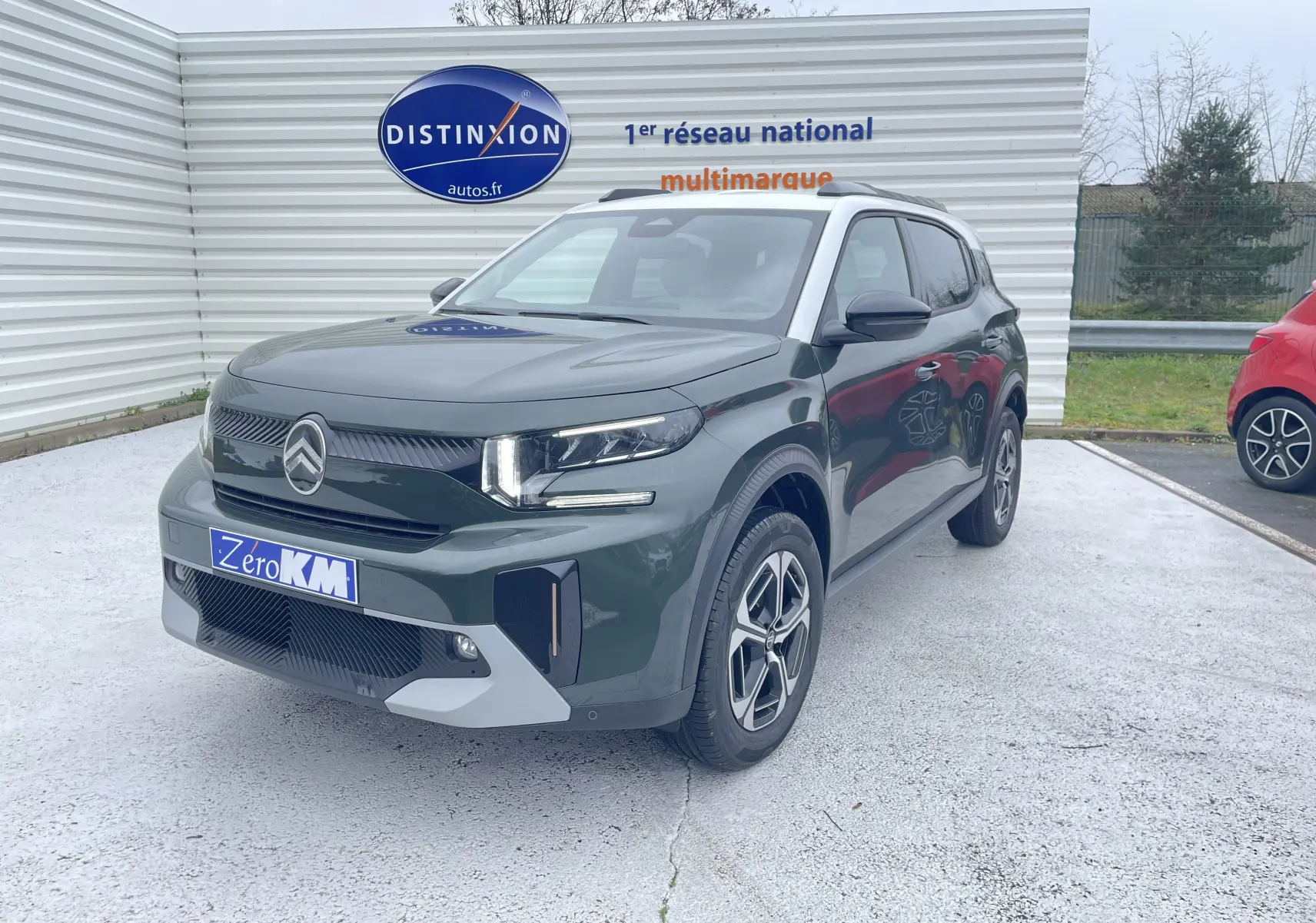 Citroën C3 Aircross hybride 2026 vert Montana avec toit blanc, vue 3/4 avant droit sur parking extérieur.