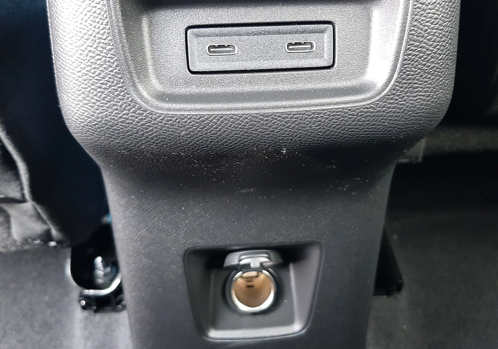 Prise USB double et prise allume-cigare noire vue de face dans l'habitacle du Citroën C3 Aircross hybride 2026.