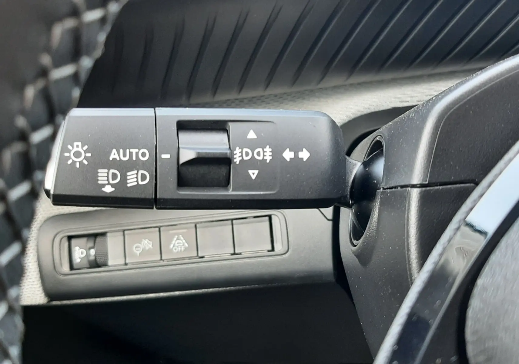 Gros plan sur la commande des feux et clignotants à gauche du volant dans l’habitacle du Citroën C3 Aircross hybride 2026.