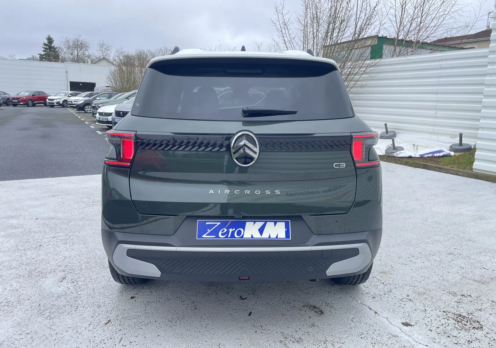 Vue arrière d'un Citroën C3 Aircross hybride 2026 vert Montana avec toit blanc opale et feux arrière LED distinctifs.