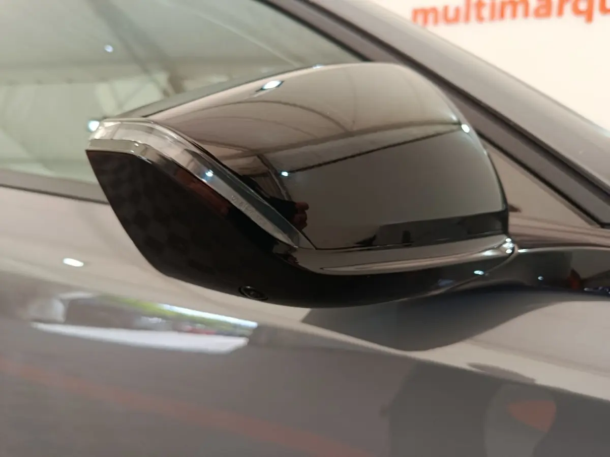 Rétroviseur côté droit noir brillant de la Peugeot 308 gris foncé, vue rapprochée en extérieur.