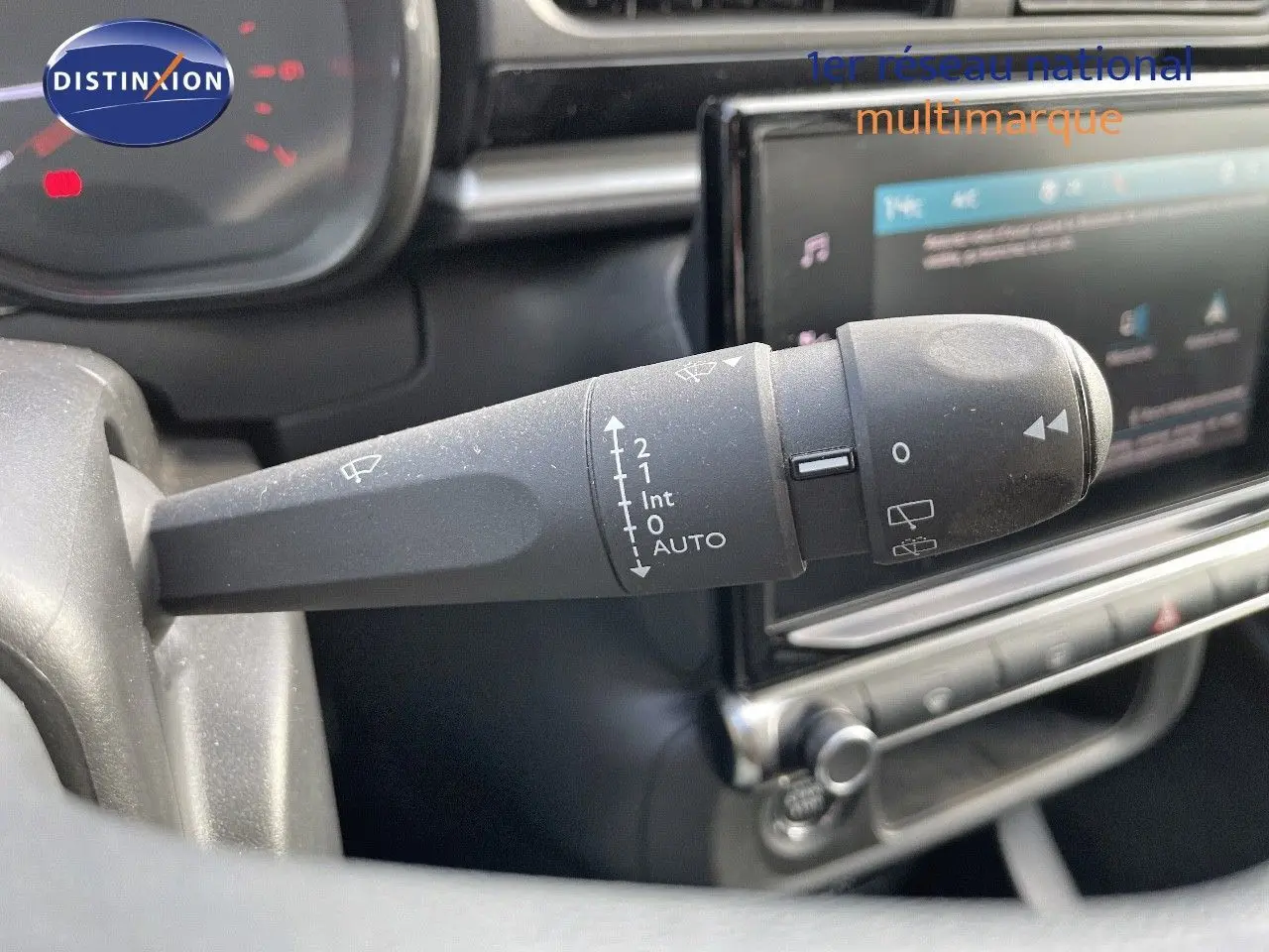 Gros plan sur la commande d'essuie-glace à gauche du volant dans l'habitacle de la Citroën C3 gris platinium 2023.