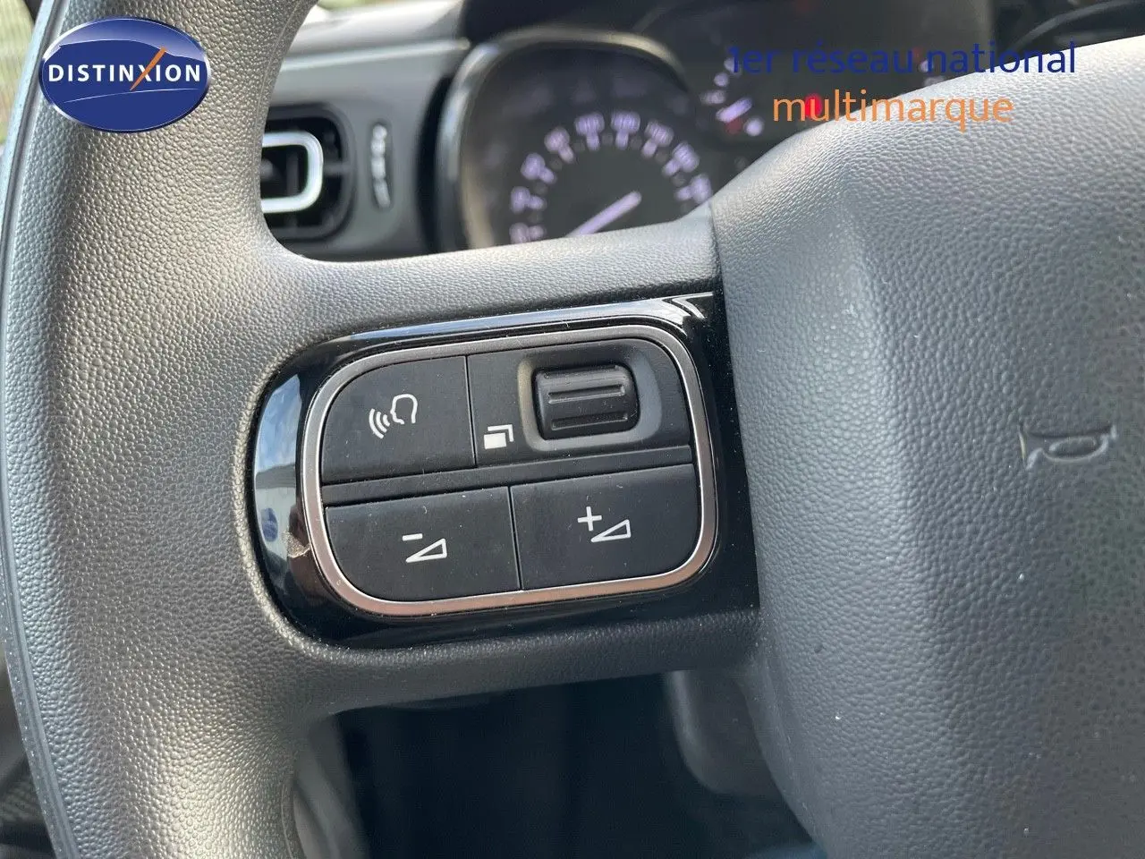 Gros plan sur les commandes au volant côté gauche de la Citroën C3 gris platinium 2023.