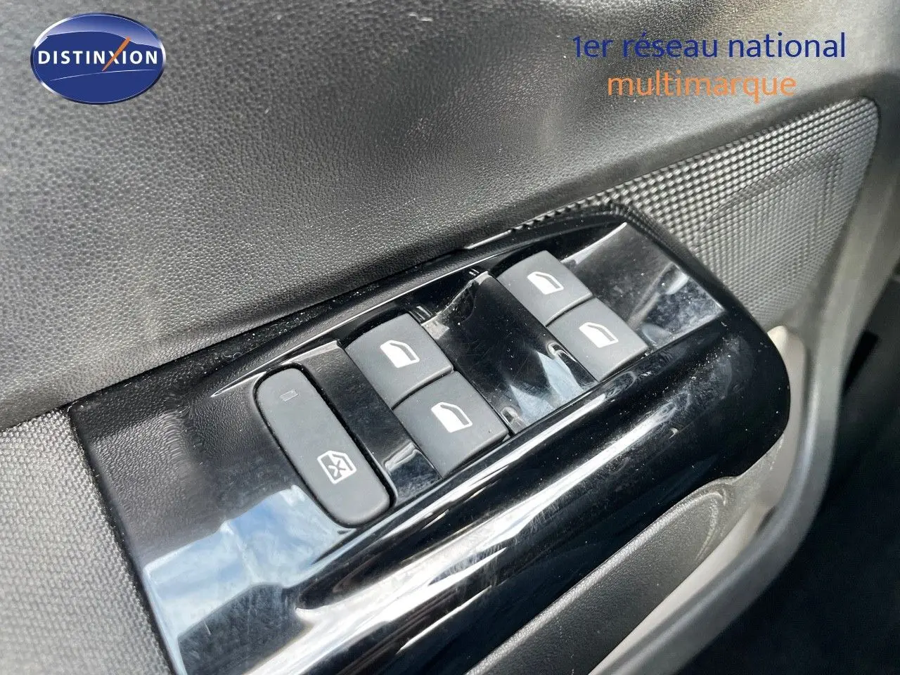 Gros plan sur les commandes des vitres électriques côté conducteur de la Citroën C3 gris platinium métal 2023.