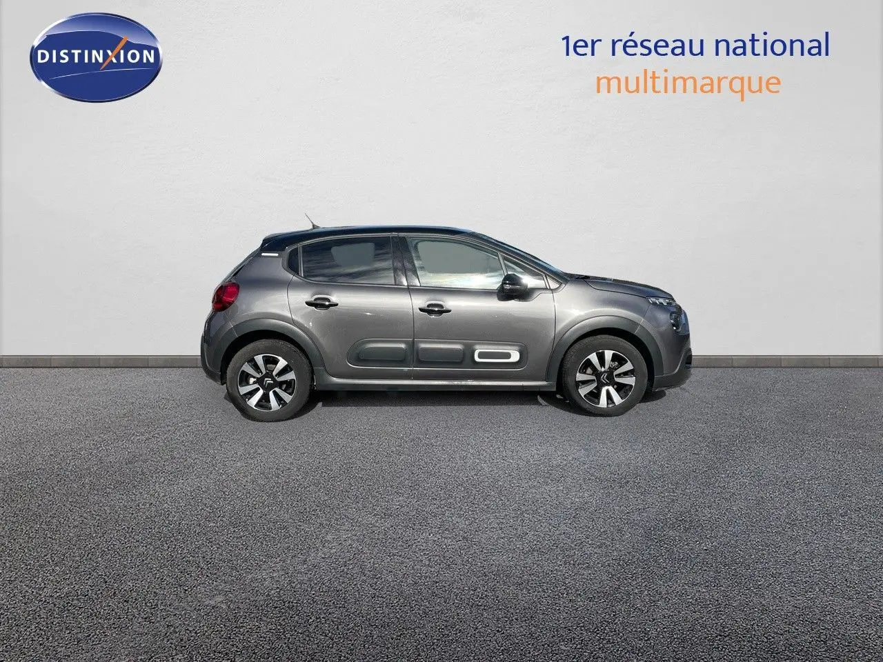 Profil côté droit d'une Citroën C3 2023 gris platinium avec protections latérales blanches distinctives.