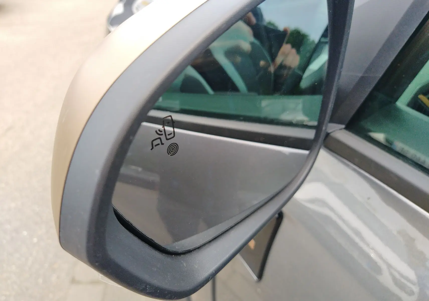 Rétroviseur côté gauche du Dacia Bigster gris schiste 2025, avec symbole d'alerte d'angle mort visible sur le miroir.
