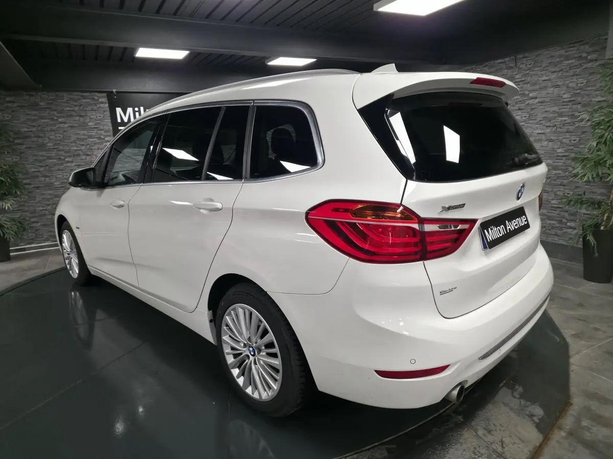 Vue 3/4 arrière droite d'une BMW Série 2 Gran Tourer blanche avec jantes alliage et feux arrière LED distinctifs.