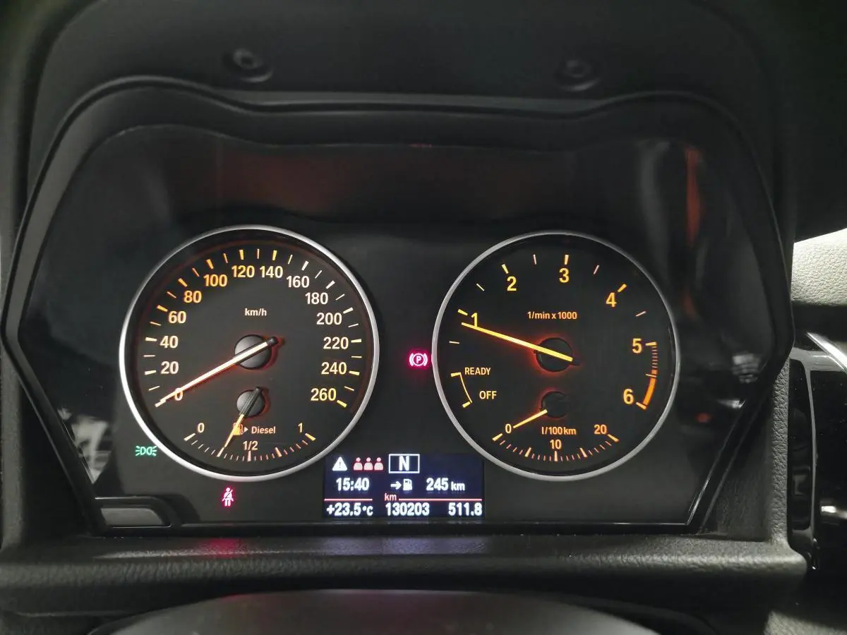 Tableau de bord éclairé de BMW Série 2 218d xDrive Gran Tourer avec compte-tours et vitesse en km/h.