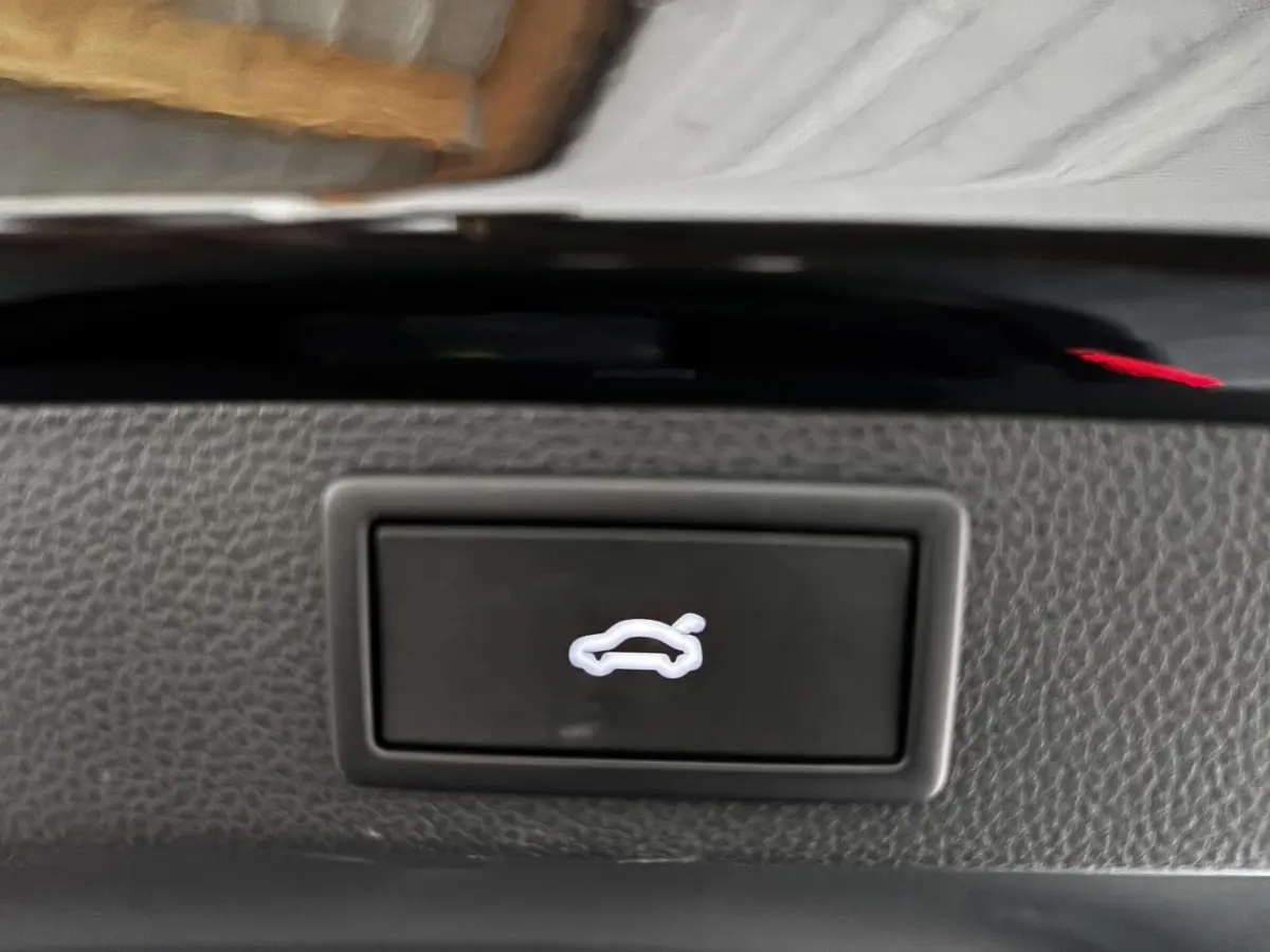 Bouton d'ouverture du coffre arrière sur tableau de bord intérieur du Skoda Karoq noir 2025.