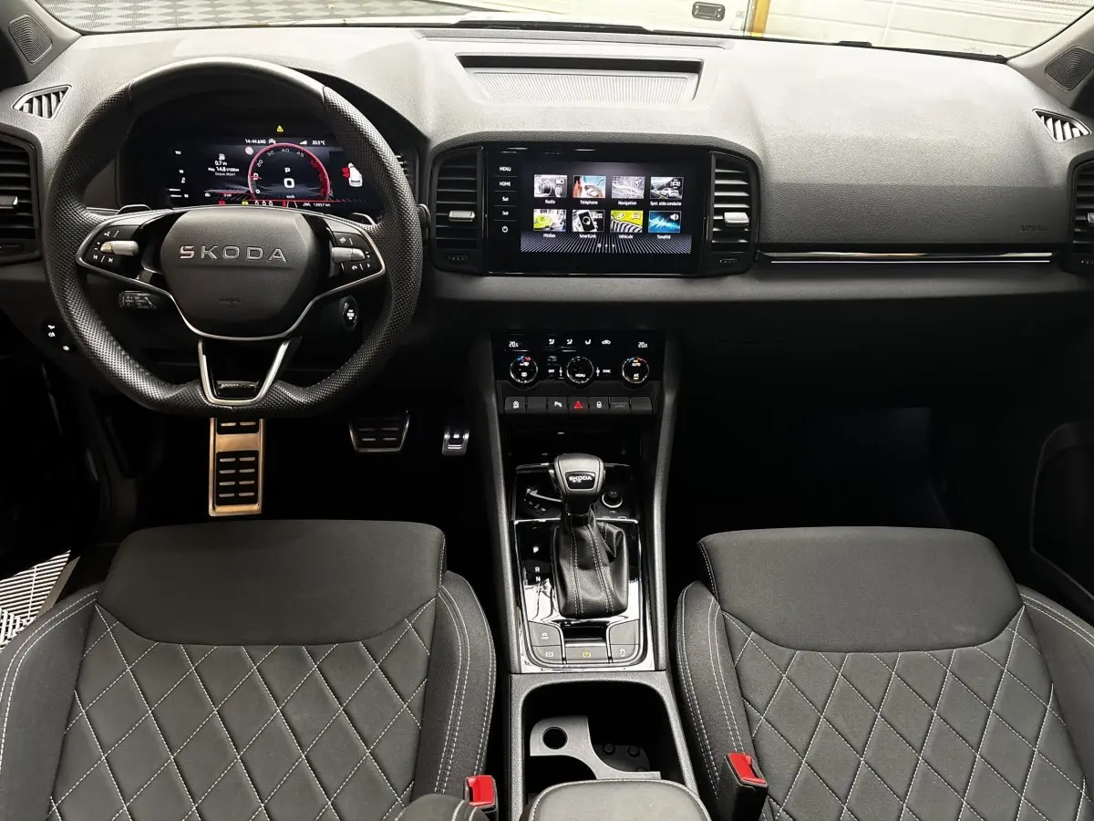 Intérieur noir du Skoda Karoq 2025, vue frontale du tableau de bord avec écran tactile et volant multifonctions.