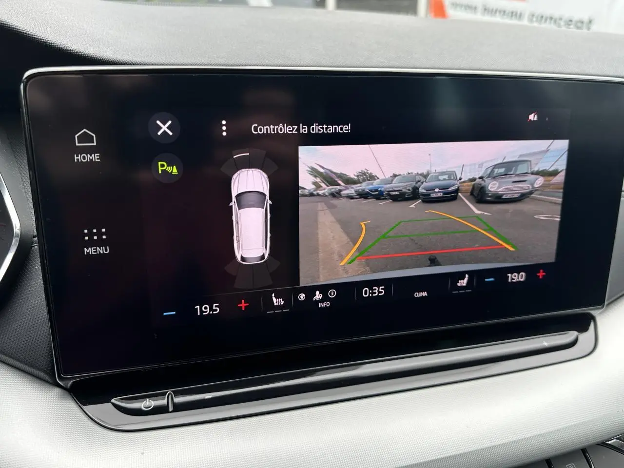 Écran central de la Skoda Octavia Combi gris graphite montrant la caméra de recul et l'aide au stationnement.