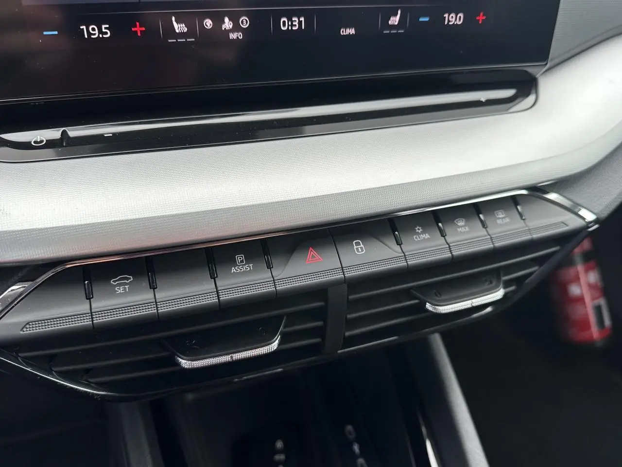 Gros plan sur la console centrale de la Skoda Octavia Combi 2024, montrant les commandes de climatisation et d'assistance.