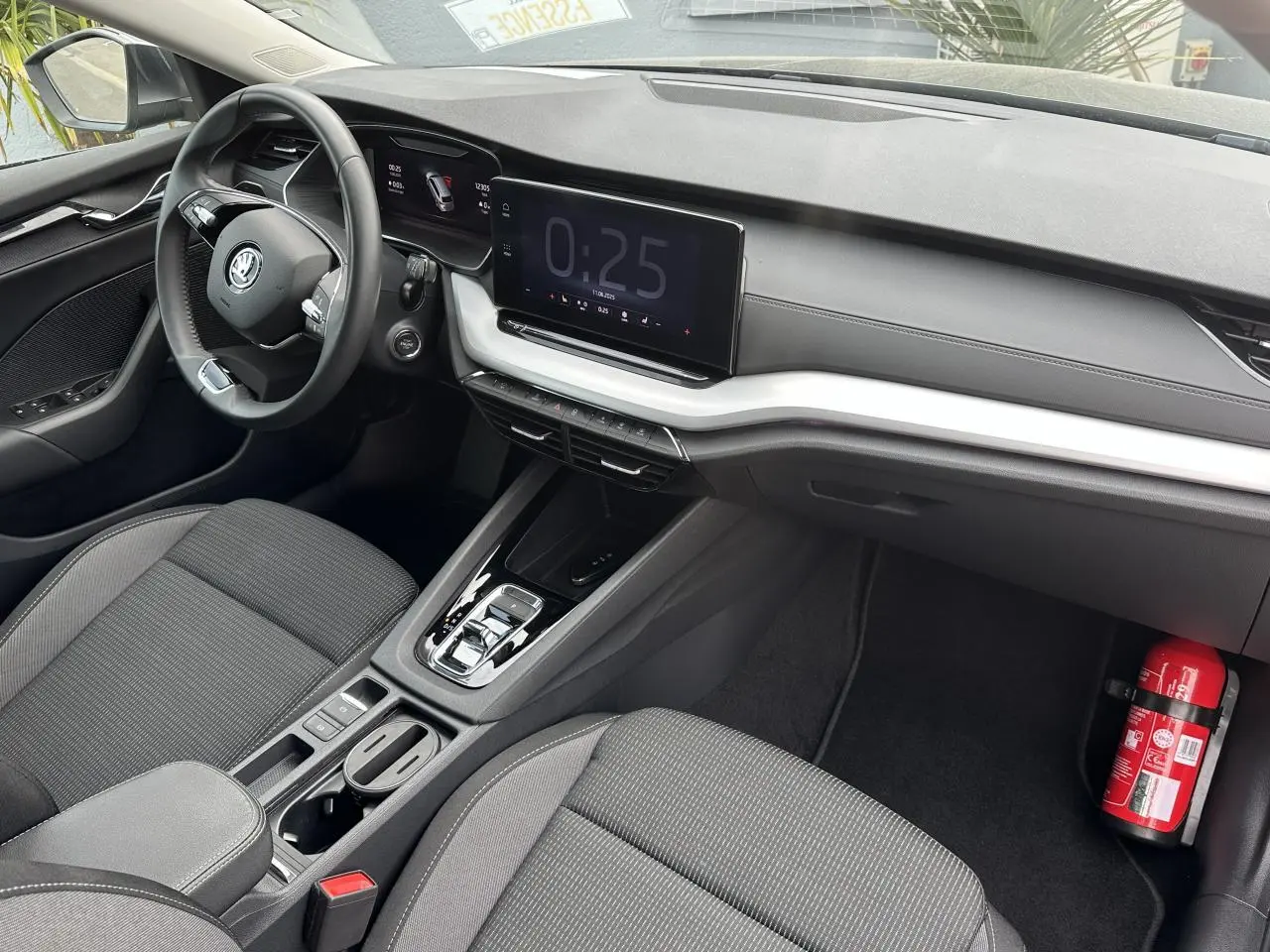 Vue intérieure côté conducteur de la Skoda Octavia Combi 2024 avec tableau de bord noir et écran tactile central.
