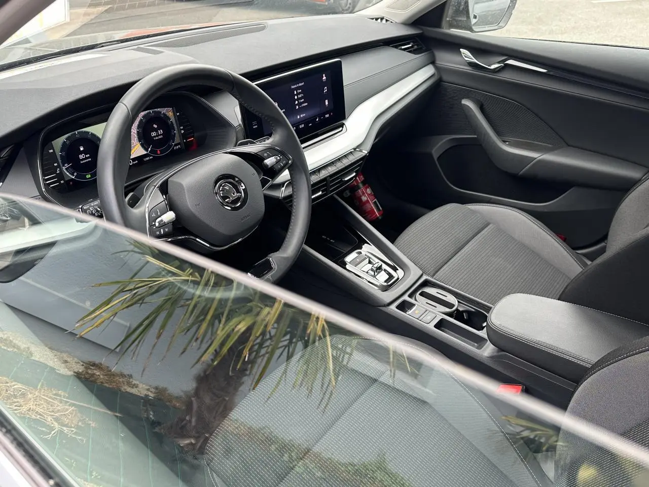Intérieur côté conducteur de la Skoda Octavia Combi 2024, volant cuir multifonctions et écran tactile central visible.