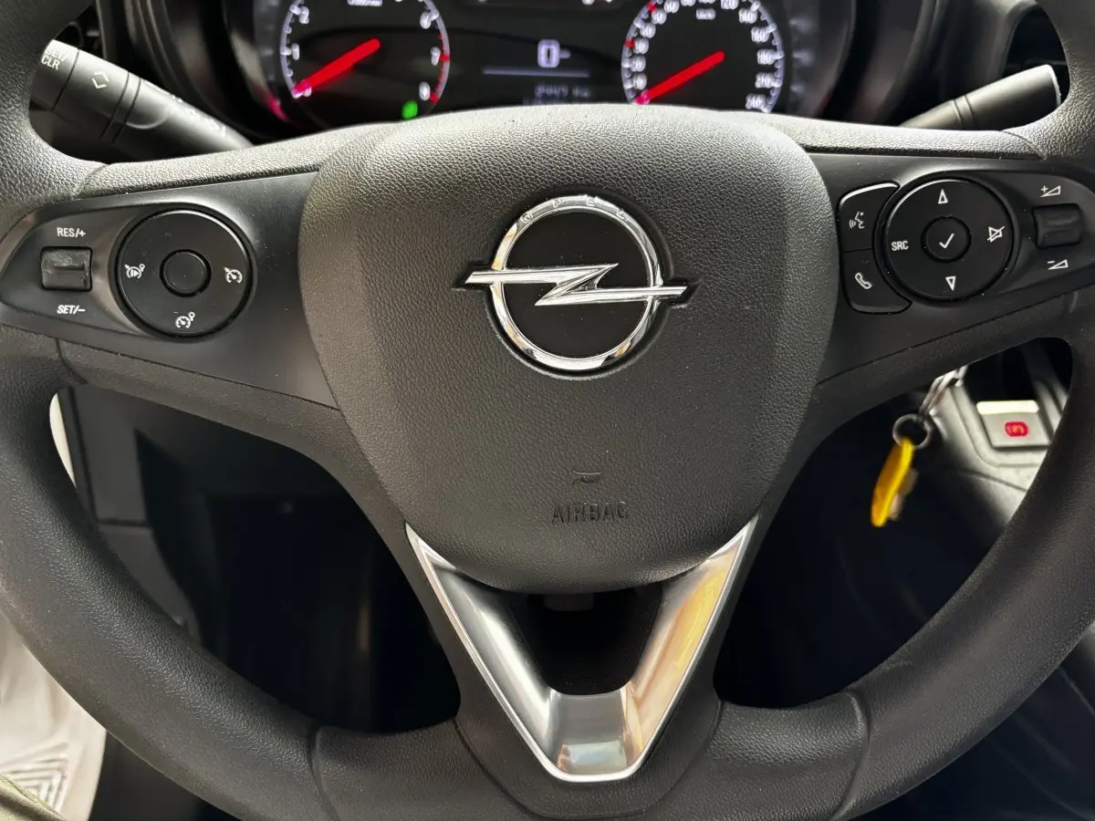 Gros plan sur le volant noir de l'Opel Combo 2021 avec commandes intégrées et logo central chromé.