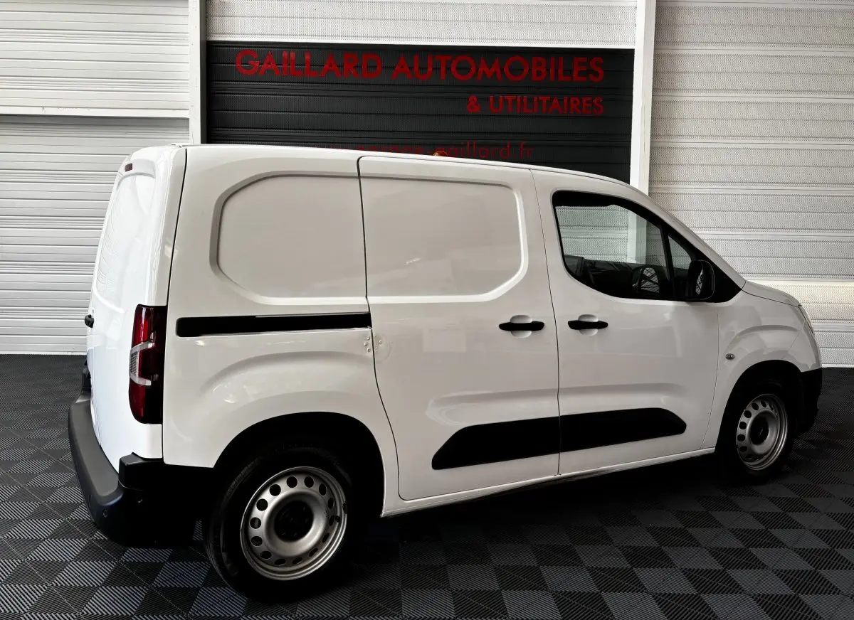 Vue de profil côté droit d'un utilitaire Opel Combo blanc avec portes latérales pleines et jantes acier.