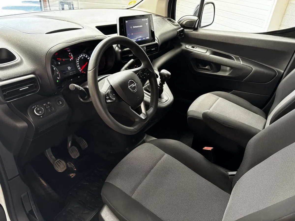 Intérieur noir et gris de l'Opel Combo 2021, vue côté conducteur montrant volant, tableau de bord et levier de vitesse manuel.