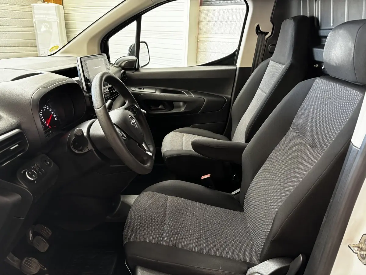 Intérieur avant droit de l'Opel Combo blanc 2021, montrant les sièges tissu gris et le tableau de bord avec écran tactile.