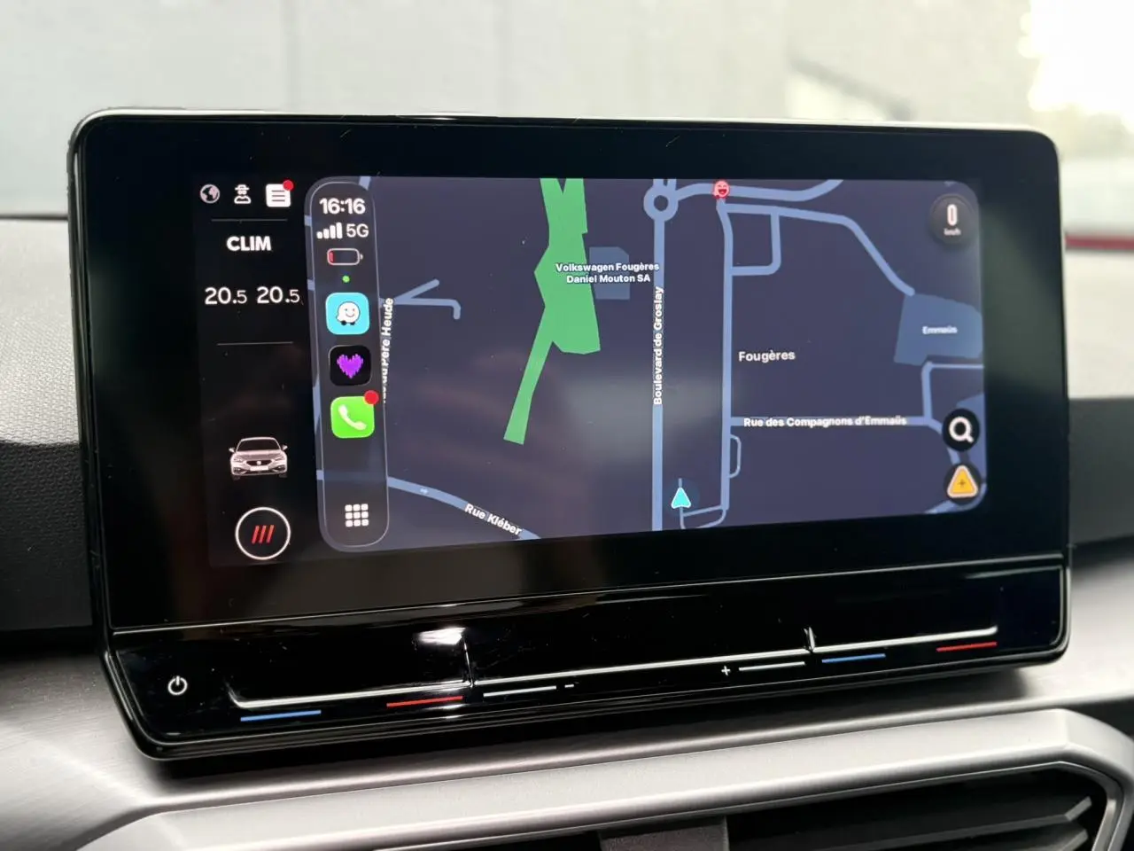 Écran tactile central du tableau de bord du SEAT Leon 2024 affichant la navigation et les commandes climatiques.