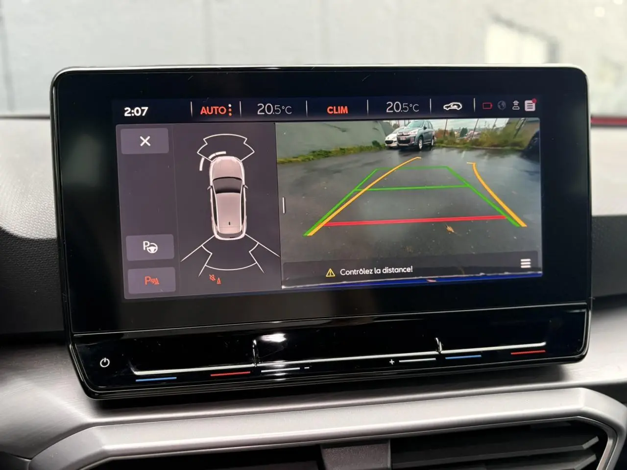 Écran tactile intérieur du SEAT Leon 2024 montrant la caméra de recul et l'aide au stationnement active.